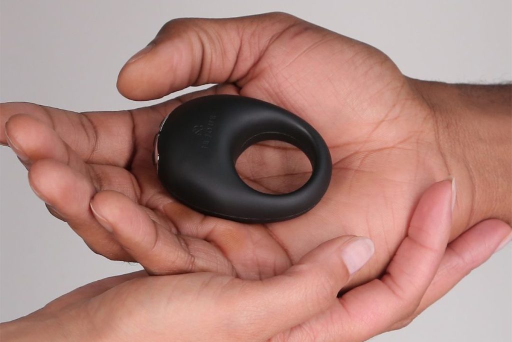 photo of a man's hand holding a vibrating cock ring.